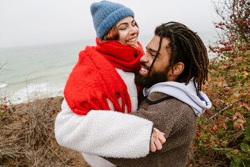 Lovely young multiethnic couple cuddling at the beach