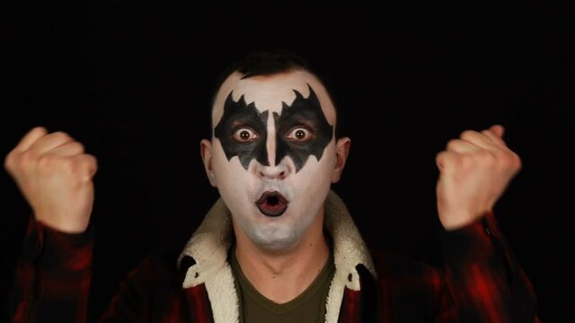 Amazed Winning Emotions of Funny Impressed Screaming Man in Demon Makeup on Black Background