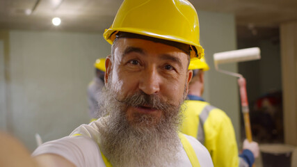 Senior builder blogger filming video about house renovation and redecoration