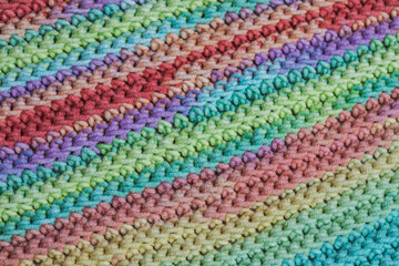 Texture of crocheted fabric from multi-colored yarn. Traditional hobby.