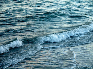 Background of an ocean surface with gentle wave splashing on the beach
