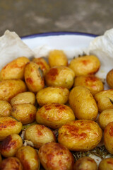 SIde view at baked potatoes in a casserole on parchment paper