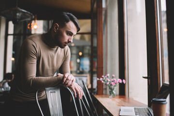 Focused male freelancer working on laptop in cafe