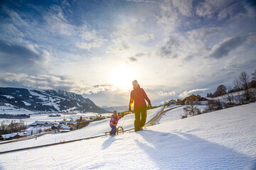 Germany, Bavaria, Allgäu, Woman and daughter enjoying a winter day sledding