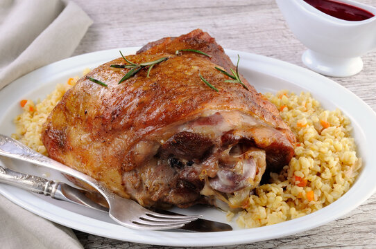 Baked turkey thigh, on the table with cranberry sauce and bulgur pilaf