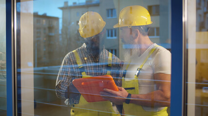 Team of builders with tablet computer working indoors