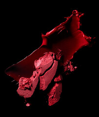 Lipstick smear and crushed eye shadow isolated on black background