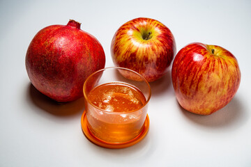 fruit, apple, pomegranate and a glass of juice are located on the table