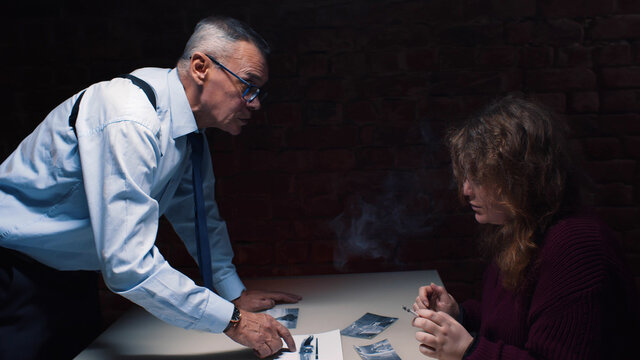 Woman smoking cigarette in interrogation room giving evidence to cop