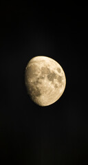 Yellow moon in black night sky close up