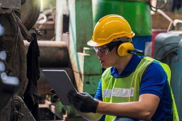 Technicians are customizing the operation of industrial machines with a tablet.