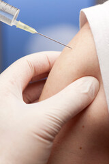 Close-up of vaccination with syringe in upper arm