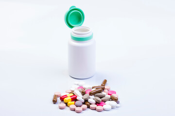 Medication bottle and white pills spilled on white background. Medication and prescription pills flat lay background. Opioid epidemic.