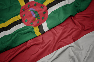 waving colorful flag of indonesia and national flag of dominica.
