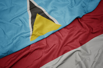 waving colorful flag of indonesia and national flag of saint lucia.
