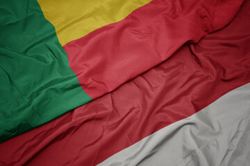 waving colorful flag of indonesia and national flag of benin.