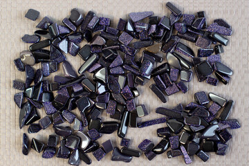 Semi-precious gemstone night cairo dark blue natural Aventurine stone on a light gray background close up