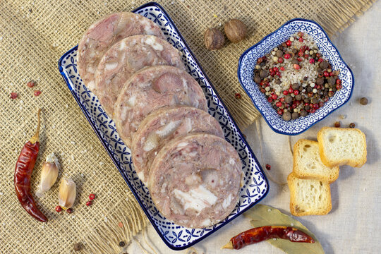 Homemade brawn headcheese meat product saltison on rough linen cloth with sea salt and spices