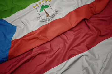 waving colorful flag of indonesia and national flag of equatorial guinea.