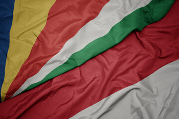 waving colorful flag of indonesia and national flag of seychelles.