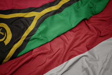 waving colorful flag of indonesia and national flag of Vanuatu .