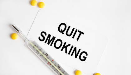 On the business card, the text of zuit SMOKING, next to the thermometer and yellow tablets.