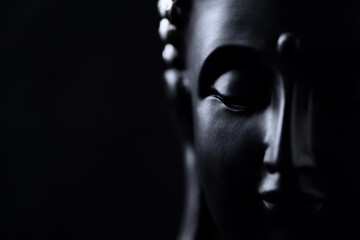 Meditating Buddha Statue isolated on black background. Copy space.	