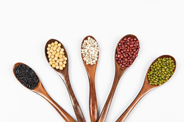 Wooden spoon with cereals, lentils, peas and beans isolated on white background