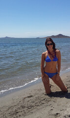 Young slim beautiful woman stay and posing in the sea or ocean waves