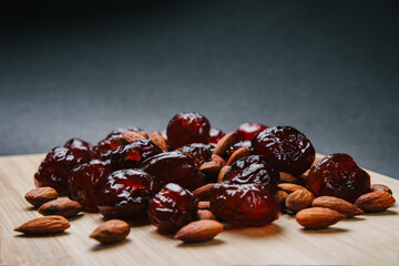 Dried dates and almonds on a wooden board