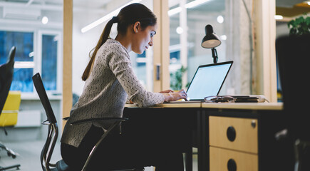 Serious female student working on laptop