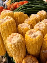 A Stack of fresh corns, carrots and long beans at traditional local market