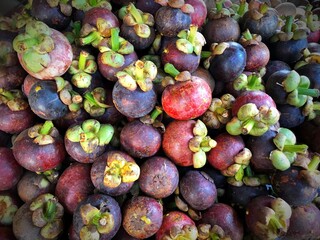 Mangosteen queen of fruit. Healthy fruits mangosteen background, dark mangosteen in a traditional local market, bunch of mangosteen ready to eat, summer tropical Asia fruit