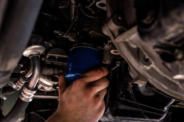 Fototapeta na wymiar Car mechanic replaces oil filter on Service station.