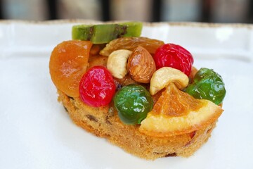 The fruit rum cake on white dish.