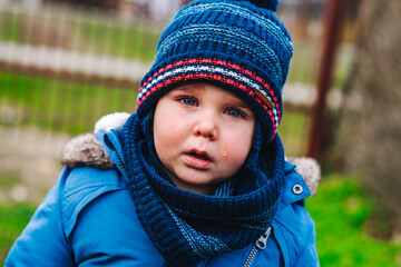 Boy being upset and crying in the park on a winter day