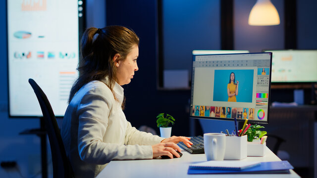 Professional woman photo retoucher working on a big project in business office at night time. Content creator doing portrait retouching using performance laptop, artist, occupation, screen, graphic