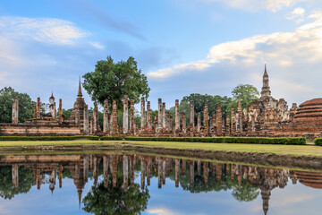 Fototapeta na wymiar Buddha statue and pagoda Wat Mahathat temple with reflection, Sukhothai Historical Park, Thailand