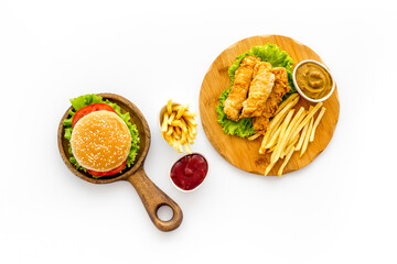 Fast food set. Delicious burger with french fries on wooden cutting board