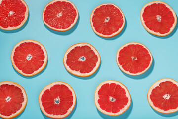 Patterns of slices of juicy Grapefruit on a blue background, a beautiful pattern.