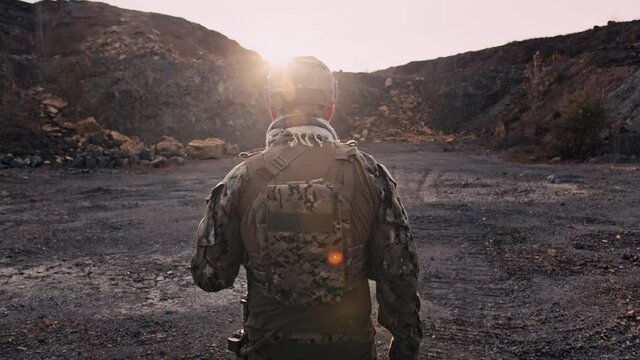 Tired special force operator comes out of the battlefield on the sunset after hard fight. Military and rescue operation concept