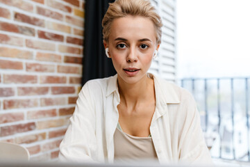 Smiling young woman on a video call via laptop