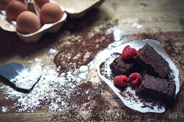 Selective focus shot of eggs and homemade chocolate brownie dessert with raspberries