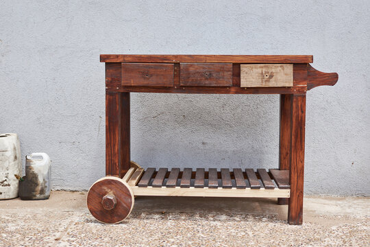 Carro mesa con ruedas en mantenimiento a medio barnizar y tarros de barniz al costado