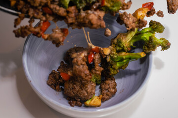 ceramic casserole of ground beef stir-fry with vegetables broccoli pepper and onion on a white base Cordoba Argentina