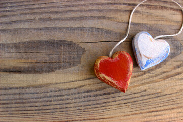 Two wooden hearts with texture and white rope isolated on old wooden background. Love and Valentine's Day concept. Retro classic Valentine Day cad. Close up