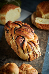 Sliced freshly baked mexican traditional pan de muerto with chocolate and cinnamon filling on a Oaxaca traditional barro negro pottery plate for the día de los muertos celebration on november 2nd