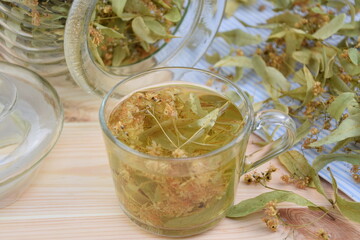 Linden tea in glass cup and jar of tilia flowers, herbal tea for cold and flu