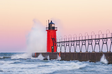 Summer landscape at dawn of the South Haven, Michigan lighthouse, catwalk, and pier with splashing...