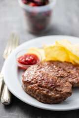 fried ground meat with tomato sauce and potato chips on dish